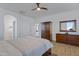 Well-lit bedroom featuring a large bed, dresser, and access to en suite bathroom at 29798 N 121St Dr, Peoria, AZ 85383