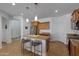 Well-lit kitchen with granite countertops, stainless steel refrigerator, modern lighting, and a breakfast bar at 29798 N 121St Dr, Peoria, AZ 85383