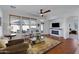 Bright living room with ceiling fan, fireplace, and seating area; large windows bring in natural light at 29798 N 121St Dr, Peoria, AZ 85383