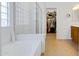Bright bathroom features a soaking tub, tiled floors and a separate glass enclosed shower at 29798 N 121St Dr, Peoria, AZ 85383