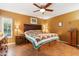 Inviting bedroom with a comfortable bed, wooden furniture, ceiling fan, and natural light from the window at 3146 W Paradise Dr, Phoenix, AZ 85029