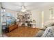 Inviting living room with custom shelving, a ceiling fan, tile flooring, and comfortable seating and entertainment space at 3146 W Paradise Dr, Phoenix, AZ 85029