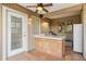 An outdoor kitchen has tile countertops, a sink, a ceiling fan, and outdoor lighting at 3146 W Paradise Dr, Phoenix, AZ 85029