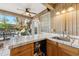 An outdoor kitchen with a tile countertop, ceiling fan, and a view of the pool at 3146 W Paradise Dr, Phoenix, AZ 85029