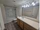Neutral bathroom featuring a shower-tub combination, tiled floor, and large vanity with ample counter space at 3420 W Danbury Dr # C218, Phoenix, AZ 85053