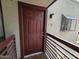 Inviting condo entrance with a sturdy red door, and decorative wall mount lighting and window features at 3420 W Danbury Dr # C218, Phoenix, AZ 85053