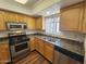 Well-lit kitchen with granite counters, modern appliances, wooden cabinets, and an undermount stainless steel sink at 3420 W Danbury Dr # C218, Phoenix, AZ 85053