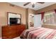 Bedroom featuring ceiling fan, dresser with TV, and access to other rooms at 3830 E Lakewood Pkwy # 1057, Phoenix, AZ 85048