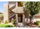 Multi-level condo complex featuring stucco siding, metal stairs, and mature landscaping near the front entrance at 3830 E Lakewood Pkwy # 1057, Phoenix, AZ 85048
