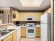Functional kitchen featuring white appliances, light yellow cabinets, and a convenient layout at 3830 E Lakewood Pkwy # 1057, Phoenix, AZ 85048
