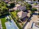 Backyard aerial view showcasing a basketball court, playground, lush lawn, detached garage, and mature trees at 3949 E Norcroft Cir, Mesa, AZ 85215