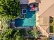 Aerial view of backyard oasis, featuring a sparkling pool with a spa, patio umbrellas, and lush tropical landscaping at 3949 E Norcroft Cir, Mesa, AZ 85215