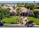 Beautiful luxury home featuring manicured landscaping, mature palm trees, a circular driveway, and a serene water fountain at 3949 E Norcroft Cir, Mesa, AZ 85215