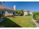 Expansive backyard featuring lush green lawn, mature landscaping, and a neutral-toned home exterior, perfect for outdoor living at 3949 E Norcroft Cir, Mesa, AZ 85215