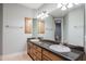 Bathroom vanity featuring double sinks, ample storage drawers, granite countertop, and modern lighting at 3949 E Norcroft Cir, Mesa, AZ 85215