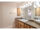 Bathroom featuring granite counters, wood cabinetry, and vanity lighting at 3949 E Norcroft Cir, Mesa, AZ 85215