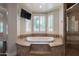 A bathtub is surrounded by light brown tile, with steps leading up to it at 3949 E Norcroft Cir, Mesa, AZ 85215