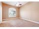 Bedroom with neutral walls, ceiling fan, plush carpet and arched window at 3949 E Norcroft Cir, Mesa, AZ 85215