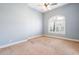 Neutral bedroom with arched window, ceiling fan, light blue walls, and plush carpet at 3949 E Norcroft Cir, Mesa, AZ 85215