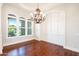 Formal dining room with hardwood floors, wainscoting detail, and designer chandelier lighting at 3949 E Norcroft Cir, Mesa, AZ 85215