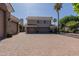 Grand home exterior featuring a three-car garage, paved driveway, and lush landscaping, offering curb appeal at 3949 E Norcroft Cir, Mesa, AZ 85215