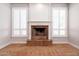Close-up of the fireplace with white frame, light brown tile, and bright windows at 3949 E Norcroft Cir, Mesa, AZ 85215