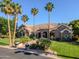 Beautiful single-story home featuring mature palm trees, lush green lawn, and desert landscaping at 3949 E Norcroft Cir, Mesa, AZ 85215