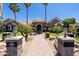 Gorgeous single-story stone home with a brick walkway, fountain, well-manicured landscaping, and towering palm trees at 3949 E Norcroft Cir, Mesa, AZ 85215