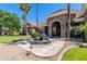 Beautiful single-story stone home with a circular driveway and lush landscaping with a fountain at 3949 E Norcroft Cir, Mesa, AZ 85215