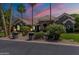Single-story stone home with beautiful landscaping and a gorgeous sunset sky at 3949 E Norcroft Cir, Mesa, AZ 85215
