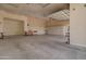 Expansive garage interior featuring a cement floor, drywall walls and an overhead garage door at 3949 E Norcroft Cir, Mesa, AZ 85215
