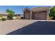 Three-car garage featuring stone accents and a spacious brick driveway, offering ample parking and curb appeal at 3949 E Norcroft Cir, Mesa, AZ 85215