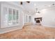 Bright and spacious living room features shuttered windows, a ceiling fan, and inviting stone fireplace at 3949 E Norcroft Cir, Mesa, AZ 85215