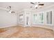 Sunlit living room with plantation shutters, two ceiling fans, and access to outdoor living spaces at 3949 E Norcroft Cir, Mesa, AZ 85215
