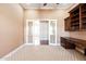 Bright office featuring double glass doors, built-in cabinets, and a desk area for productivity and comfort at 3949 E Norcroft Cir, Mesa, AZ 85215