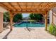 Inviting pool area with a pergola, waterfall feature, and lush landscaping, perfect for outdoor entertainment and relaxation at 3949 E Norcroft Cir, Mesa, AZ 85215