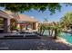 Backyard with swimming pool, spa, patio with umbrellas, and mature landscaping for outdoor enjoyment at 3949 E Norcroft Cir, Mesa, AZ 85215