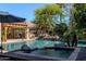 Resort-style pool and spa with lush landscaping and a covered outdoor living space, perfect for relaxation and entertaining at 3949 E Norcroft Cir, Mesa, AZ 85215