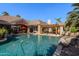Backyard pool area with patio, pergola with basketball hoop and beautiful mature palm trees at 3949 E Norcroft Cir, Mesa, AZ 85215