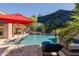 Beautiful pool featuring rock waterfall and shady umbrellas, perfect for backyard relaxation at 3949 E Norcroft Cir, Mesa, AZ 85215