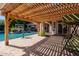 Beautiful pool area with a pergola, seating area, and manicured landscaping, perfect for outdoor relaxation and entertainment at 3949 E Norcroft Cir, Mesa, AZ 85215