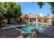 Beautiful backyard pool area with lush landscaping, a diving board, and covered patio at 3949 E Norcroft Cir, Mesa, AZ 85215