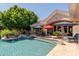 Sparkling pool with an integrated spa, lounge chairs, and patio umbrellas, creating a luxurious outdoor oasis at 3949 E Norcroft Cir, Mesa, AZ 85215