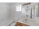 Bright bathroom with large mirror, window, white tile surround, and wooden vanity offers functionality at 4319 E Tanglewood Dr, Phoenix, AZ 85048