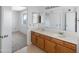 Bathroom featuring double sinks, wood cabinets, and access to another room at 4319 E Tanglewood Dr, Phoenix, AZ 85048