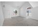 Open living room with neutral carpet, a tiled entryway, ceiling fan, and an arched window at 4319 E Tanglewood Dr, Phoenix, AZ 85048