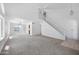 Spacious living room featuring neutral carpet, white walls, ceiling fans, and a staircase at 4319 E Tanglewood Dr, Phoenix, AZ 85048