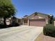 Well-maintained home featuring a spacious driveway and two-car garage, complemented by lush landscaping at 45290 W Buckhorn Trl, Maricopa, AZ 85139