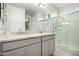 Bathroom featuring a dual sink vanity with granite counters, a glass-enclosed shower, and a door to a second room at 4701 S Siphon Draw Rd, Apache Junction, AZ 85119