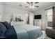 The bedroom offers a restful blue bed set, a mirror and dresser, and a glimpse into an attached bathroom at 4701 S Siphon Draw Rd, Apache Junction, AZ 85119